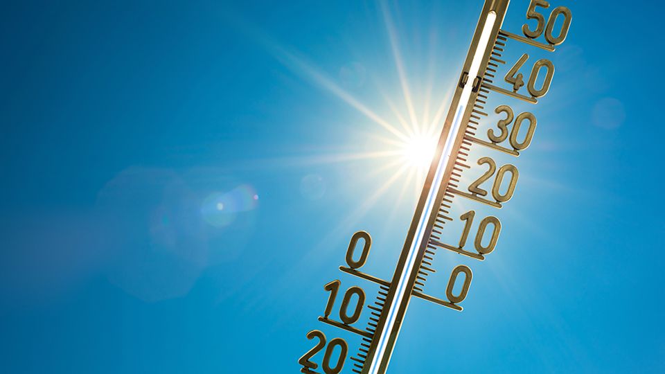 Thermometer with bright sun and blue sky